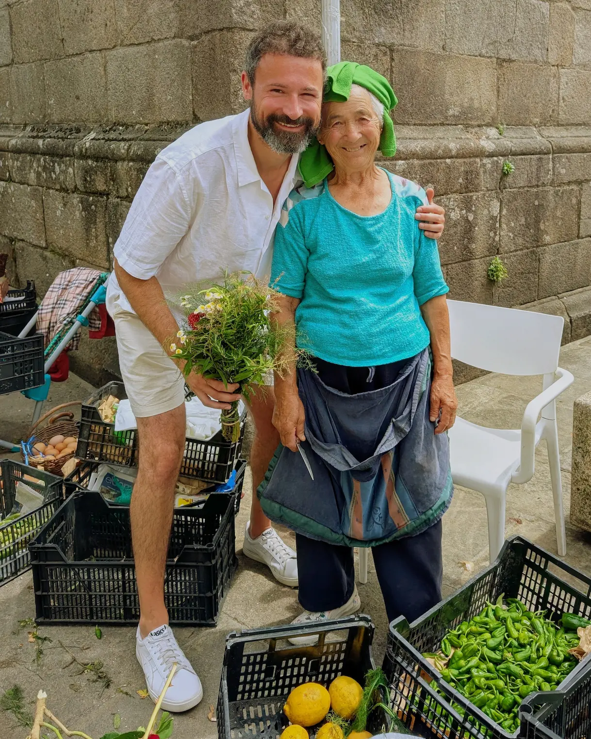 Eine Marktfrau auf dem Markt in Santiago de Compostela erklärt Kräuter