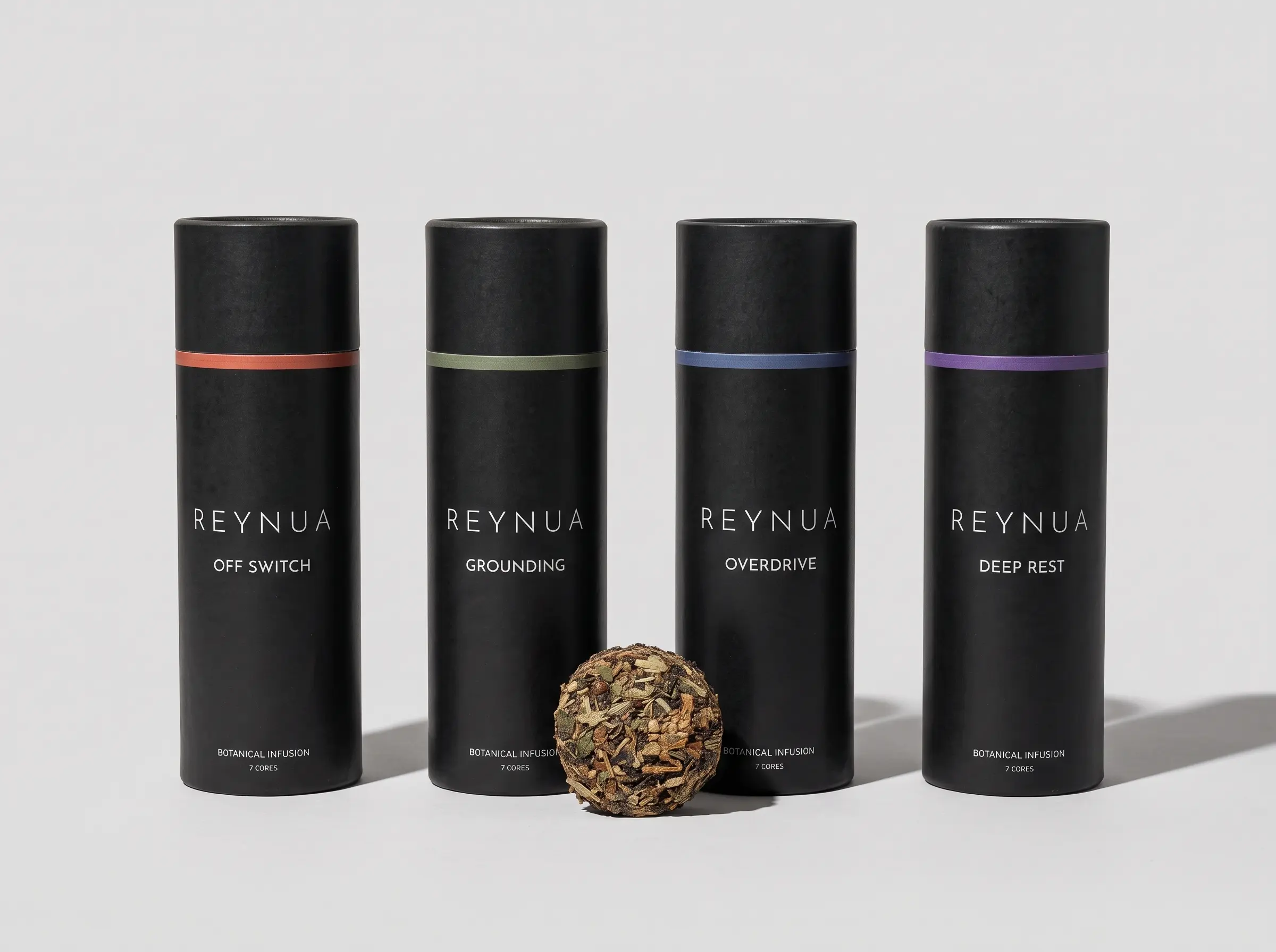 Vier REYNUA Tubes mit farbigen Ringen, ein Glas Tee, ein Core in der Hand und der Core-Infuser